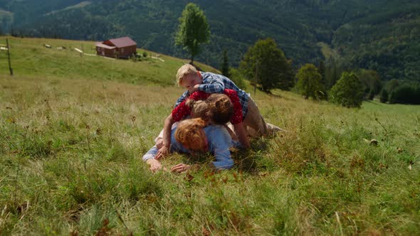 Happy Family Lying Piled Top Each Other on Green Hill