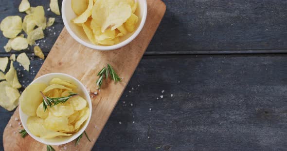 Close up view of two bowls of potato chips on wooden tray with copy space on wooden surface