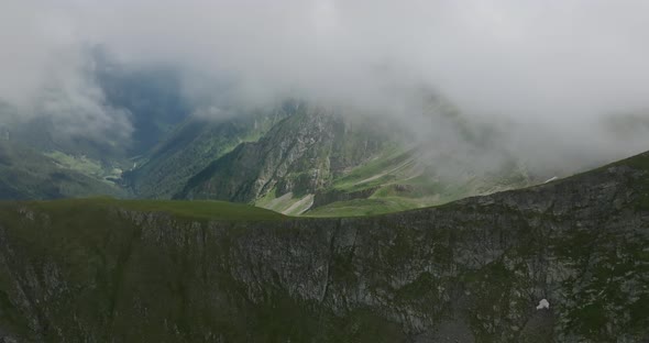 flying in clouds in mountains passing over mountain range