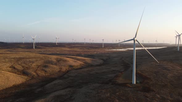 Wind turbine for eolic energy production in Scottish countryside, Aerial drone ascending