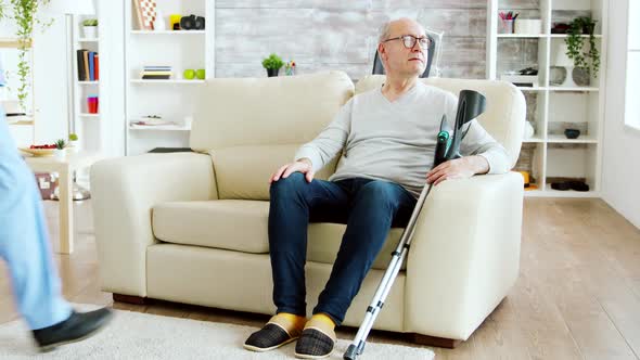 Revealing Shot of Male Nurse Checking on Retired Old Man with Alzheimer