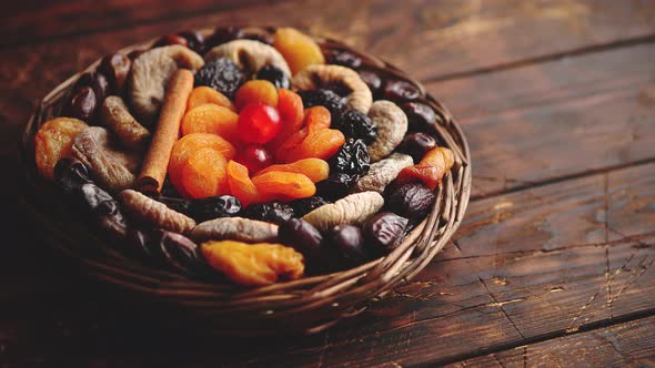 Mix of Dried Fruits in a Small Wicker Basket on Wooden Table