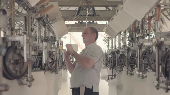 Worker working at a circular knitting machine in knitting factory