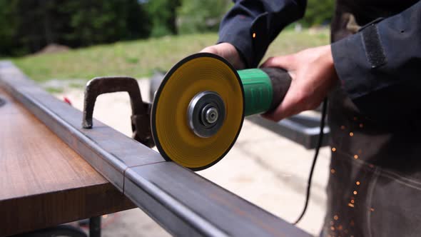 A Women Welding Iron with a Disc Shaped Grinder