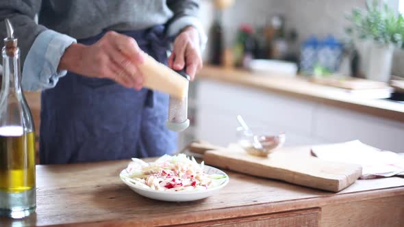 Woman grating cheese over salad