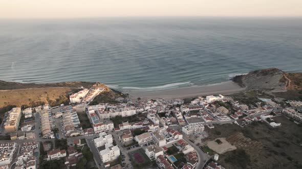 Aerial shot facing directly at the Atlantic Ocean from a secluded fishing village Burgau Portugal.