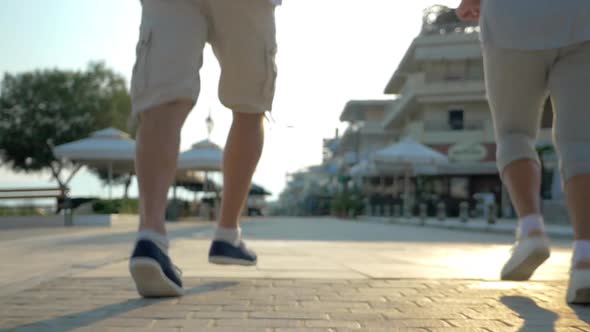 Two people running on the pavement