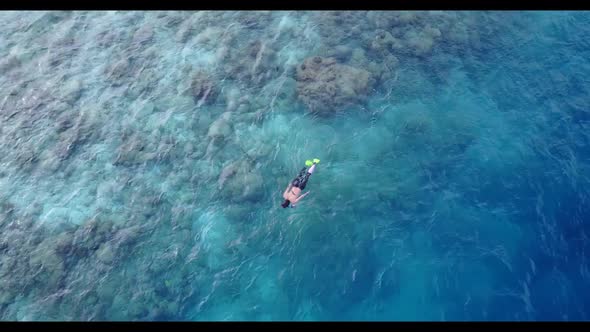 Man and lady happy together on tranquil tourist beach vacation by aqua blue ocean with white sandy b