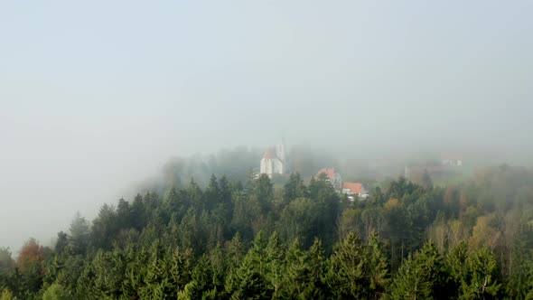 Mysterious catholic church hidden in forest and misty clouds like a horror movie