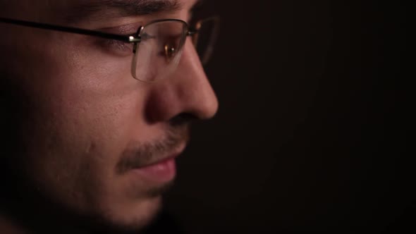 Man in Eyeglasses Late at Night Coder Programmer or Developer Using Laptop in Dark
