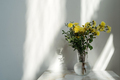 Vase with beautiful yellow flowers in front of white wall. Contrast shadows on the white wall. Count - PhotoDune Item for Sale