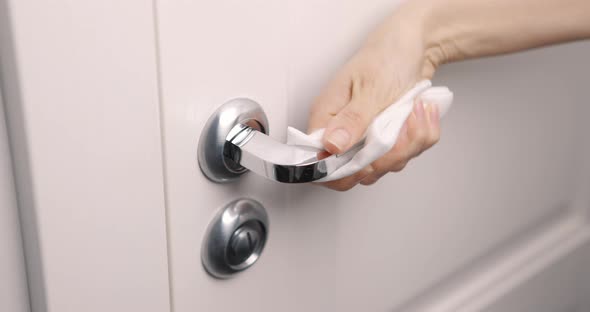 Female Hand Cleaning and Disinfecting Door Handle By Wet Wipe with Antiseptic to Prevent Covid19