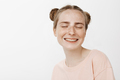 Close-up shot of carefree tender female with cute buns hairstyle and freckles, smiling joyfully with - PhotoDune Item for Sale