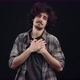 The Grateful and Emotional Curly Young Man Puts His Palms in the Heart Area and Positions His - VideoHive Item for Sale