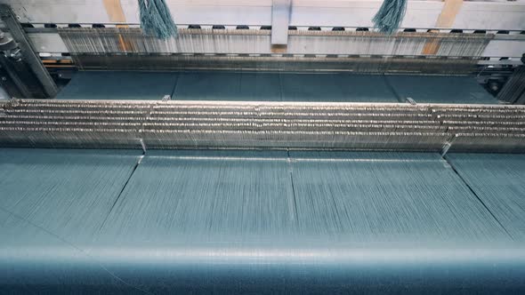 Weaving Machine with Lots of Threads Going Quickly Through It