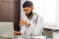 Portrait of indian man doctor talking to online patient on laptop online consultation - PhotoDune Item for Sale