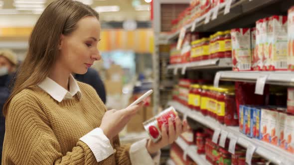 Woman Scans Information From the Barcode of a Tomato Jar Using Her Smartphone