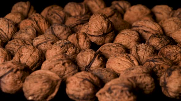 Organic, Vegan-Approved Walnuts Falling into Pile, Close-Up, Slow Motion