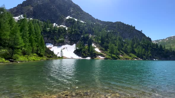 Panorama shot of nature Lake between Austrian mountains covered with snow in summer. Wide angle shot