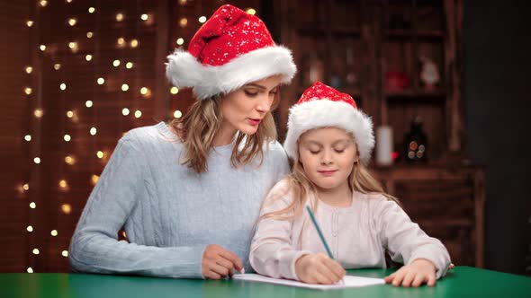 Happy Mother and Daughter Writing Letter with Wishes to Santa Claus