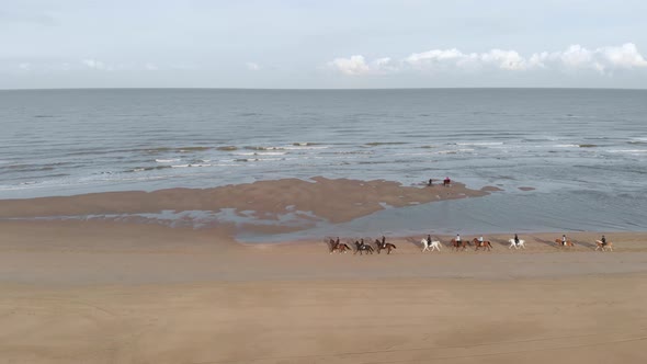 Aerial View Of People Horseback Riding At The Beach In Netherlands.