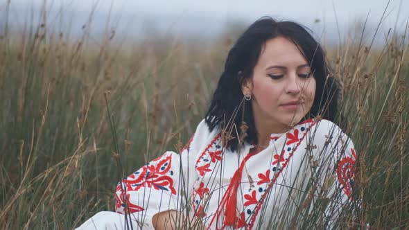 Portrait of Cheerful Charming Young Ukrainian Woman in National Clothes in Field