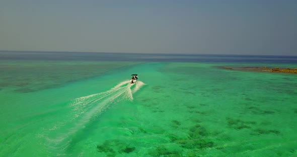 Natural fly over copy space shot of a sunshine white sandy paradise beach and blue sea background in