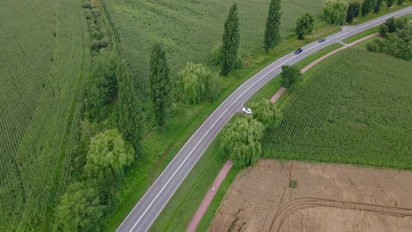 Aerial View of Cars Moving on Road Through Agricultural Fields