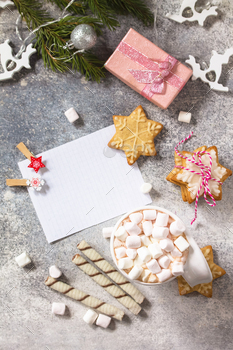 Christmas background. White list and cup of hot cocoa with marshmallows and Christmas baking.
