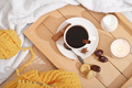cinnamon coffee in a white cup, dry fruits, milk and candle in a wooden tray. - PhotoDune Item for Sale