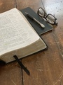 An Open Black Leather Bible Sits atop an Old Weathered Wooden Table - PhotoDune Item for Sale