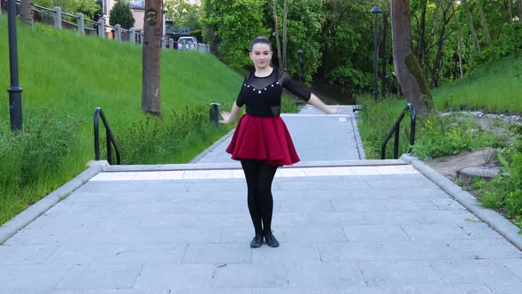 Stunning female dancer dances outside in the park