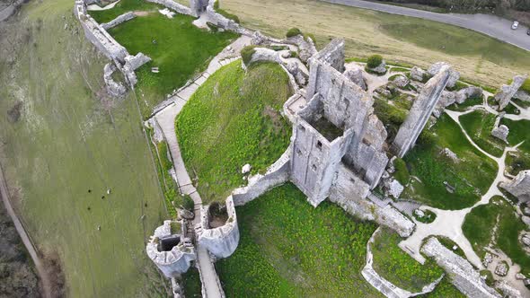 Aerial top-down approach over spectral remains of Corfe castle ruins. Dorset in England