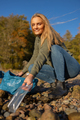 Smiling young woman in environment conservation team picking up plastic at beach - PhotoDune Item for Sale