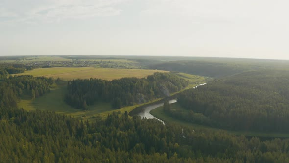 Aerial View of the River with a Rock and Forest on the Banks