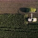 Aerial shot of modern harvester loading off corn on tractor trailers. - VideoHive Item for Sale