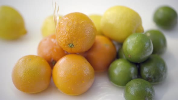 SLOMO of Water Poured on Citrus on White Backdrop