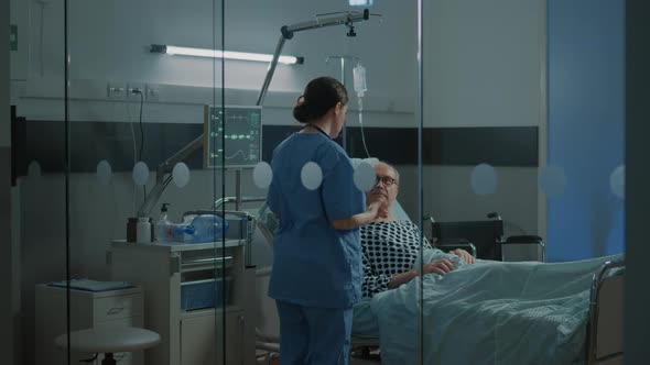 Sick Patient in Hospital Ward Getting Help From Medical Team