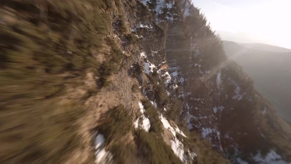 fpv drone diving down an austrian mountain at spring in the evening sun