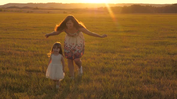 Happy Family Mom and Daughter Are Playing on Green Field