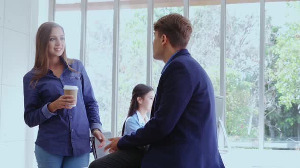 Happy Businesswoman and Businessman Having Conversation in Modern Office