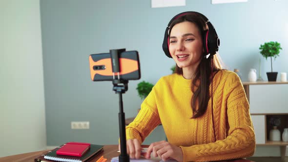 Happy Young Teacher in Headphones Communicates By Video Call Using Mobile Phone