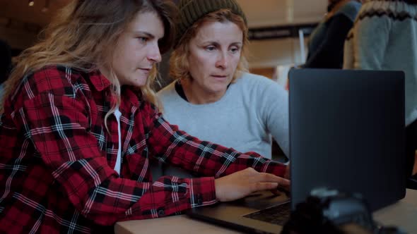 Two Women Work on Laptop in Cafe or Coworking