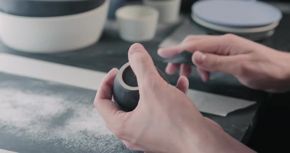 Slow Motion Man Hands Polishing Bottom of Black Ceramic Cup