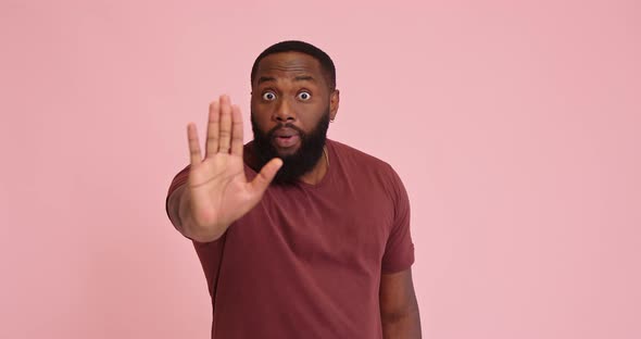 Young African American Man Show Stop Hand Gesture on Pink Background