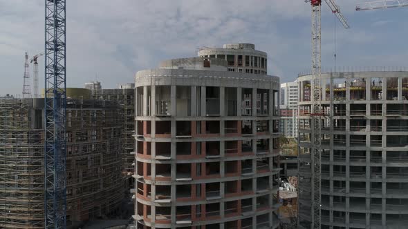 Aerial shot of construction of high-rise apartment buildings and cranes in city 03