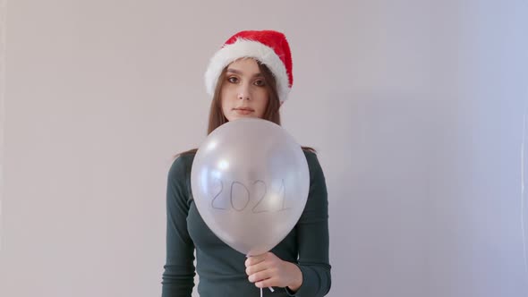 Young Female Green Shirt and Red Santa Hat Holding White Balloon 2021 Let Fly