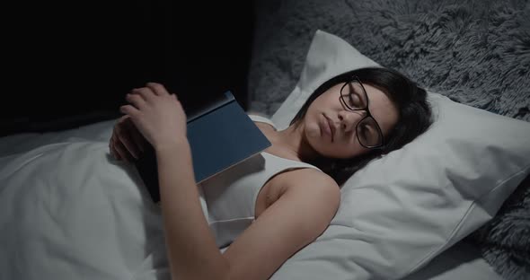 Woman Sleeping with Book in Bed