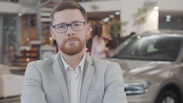 Close-up Face of Young Caucasian Car Dealer Gesturing Yes By Shaking Head and Smiling