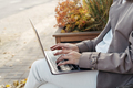 Female typing on laptop keyboard outdoors. Woman using laptop in the city - PhotoDune Item for Sale
